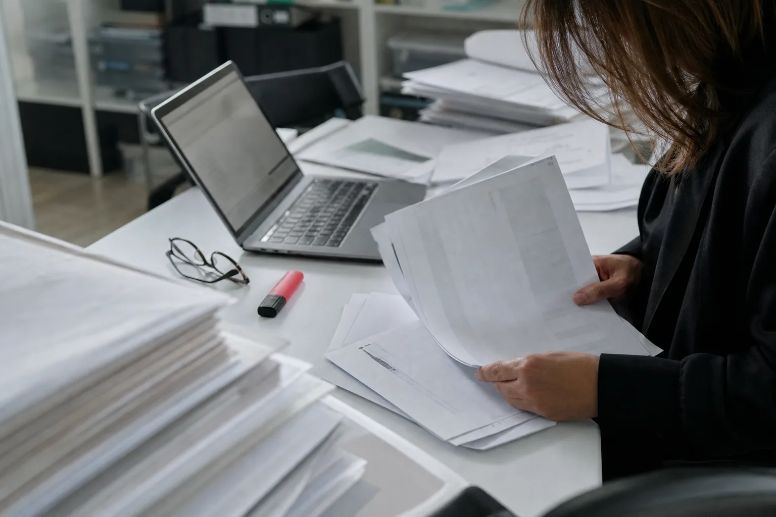 Dokumenty rejestrowe spółki rozłożone na biurku obok laptopa